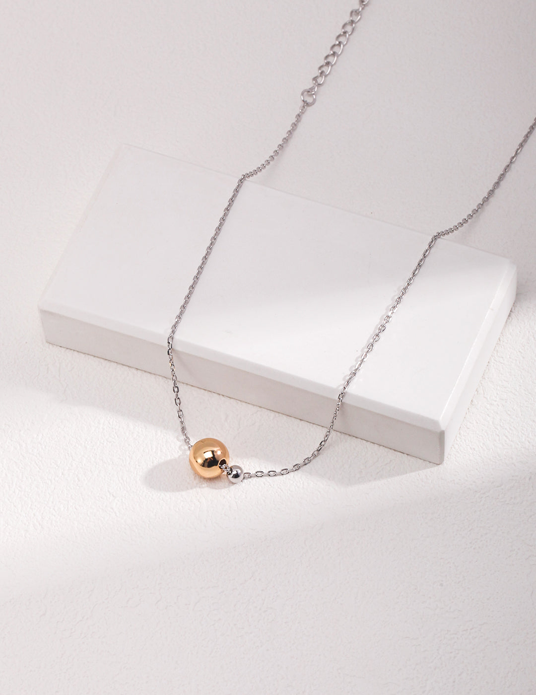Silver Necklace Featuring a Luxurious Golden Sphere Pendant
