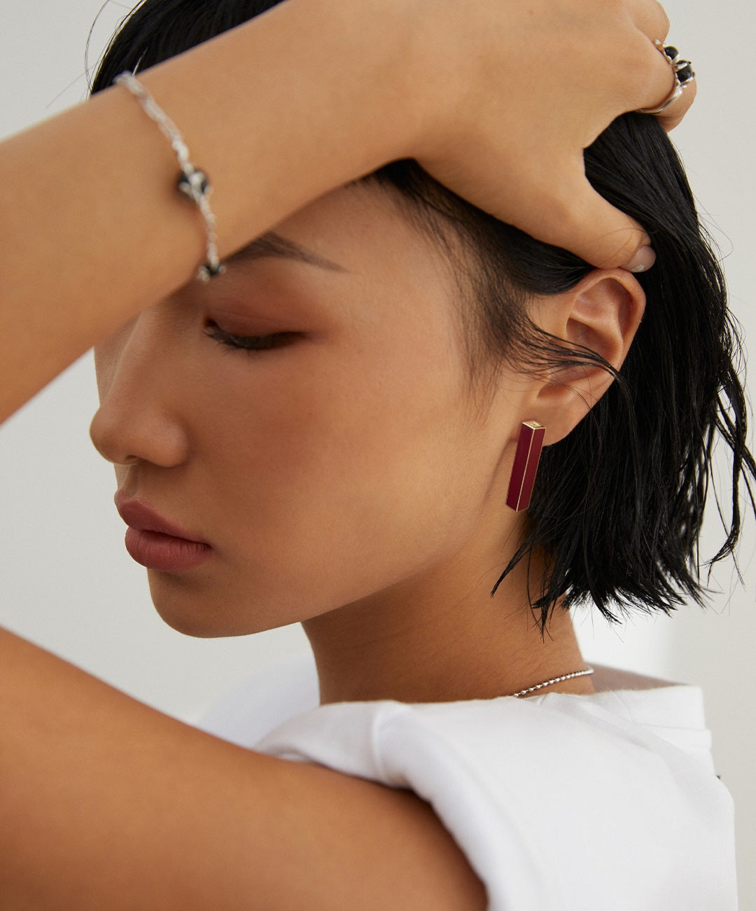 a lady wearing a Stylish yet minimalist gold earrings with vintage red drip glaze on it