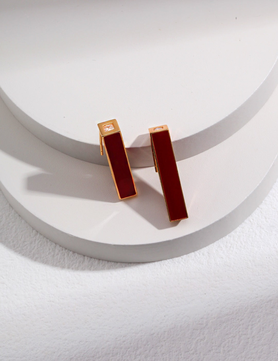 focus shot of an elegant 18k gold-plated stud earrings with red drip glaze