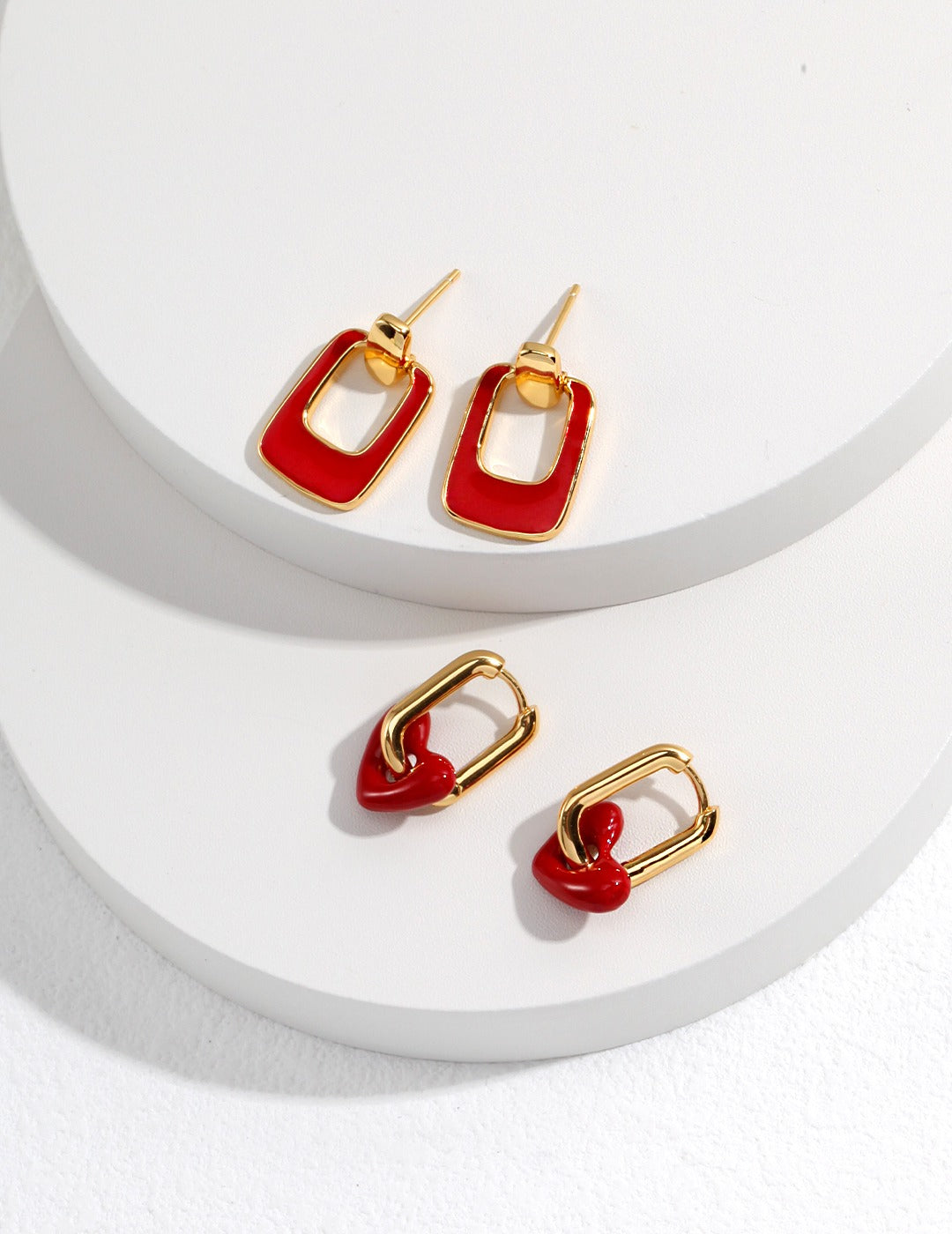 collection of minimalist gold earrings with a bold red color drip glaze